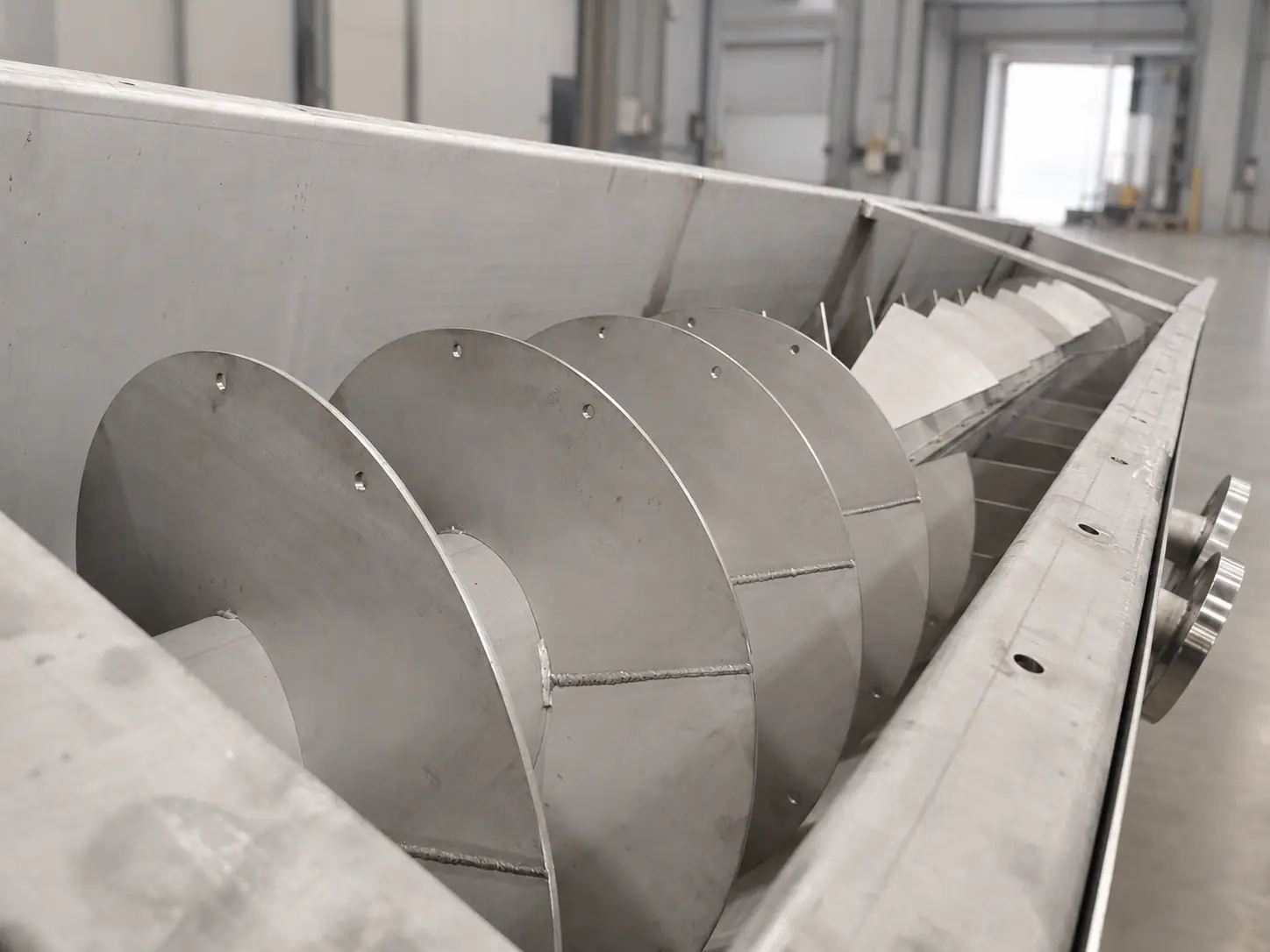 Screw conveyor flights mounted in their trough
